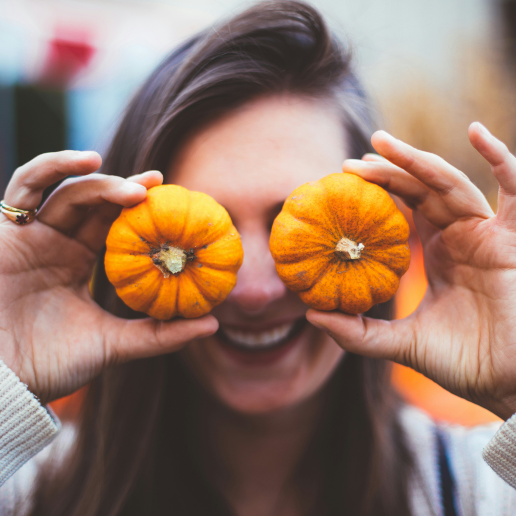 A woman holding two pumpkin