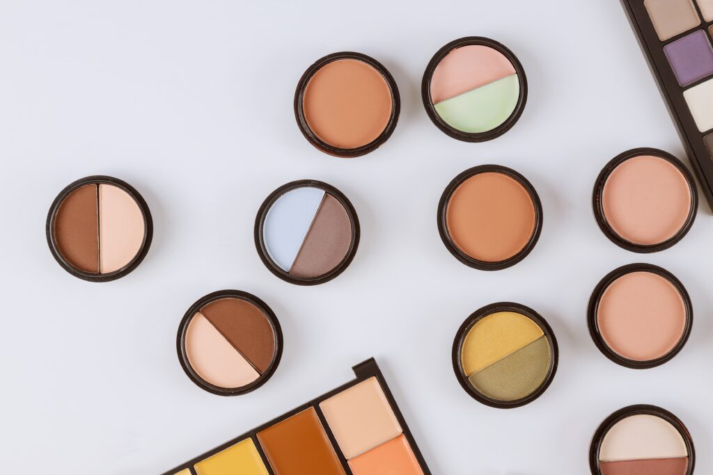 Color correction. Set of concealers in pastel colors pallet, close up of make up product on an isolated white background