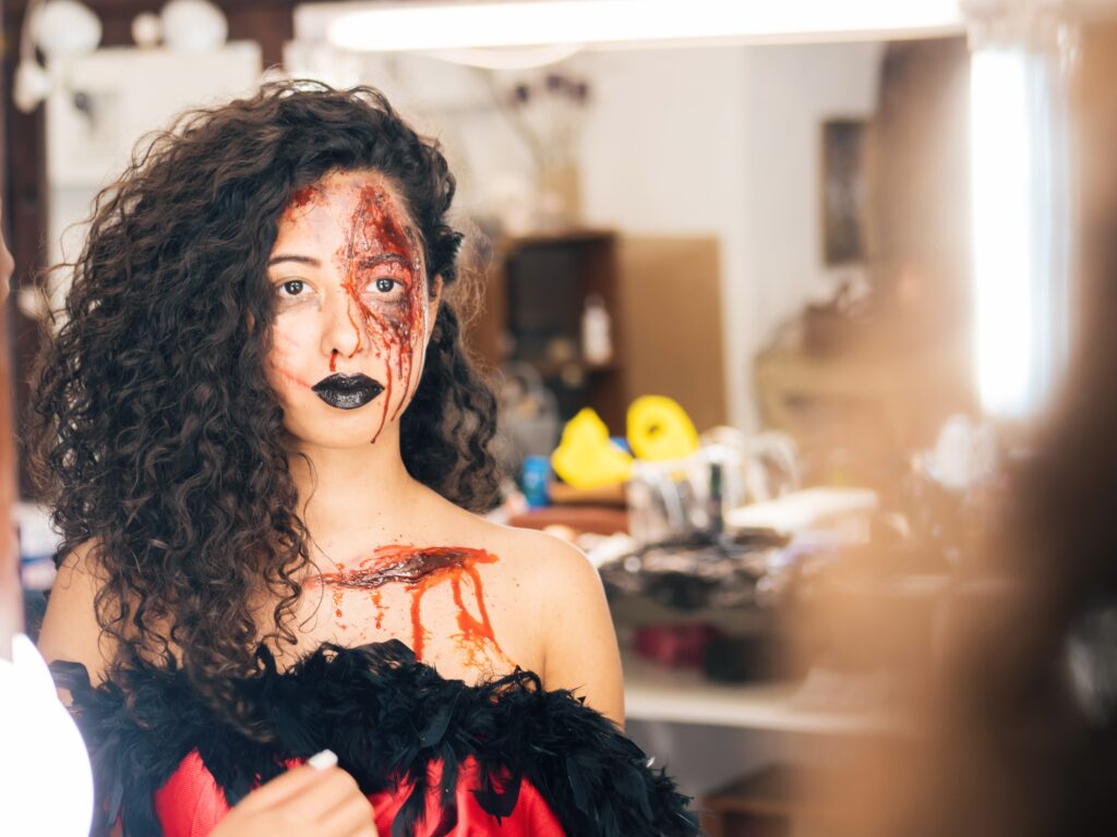 Woman looking at a mirror with Halloween makeup