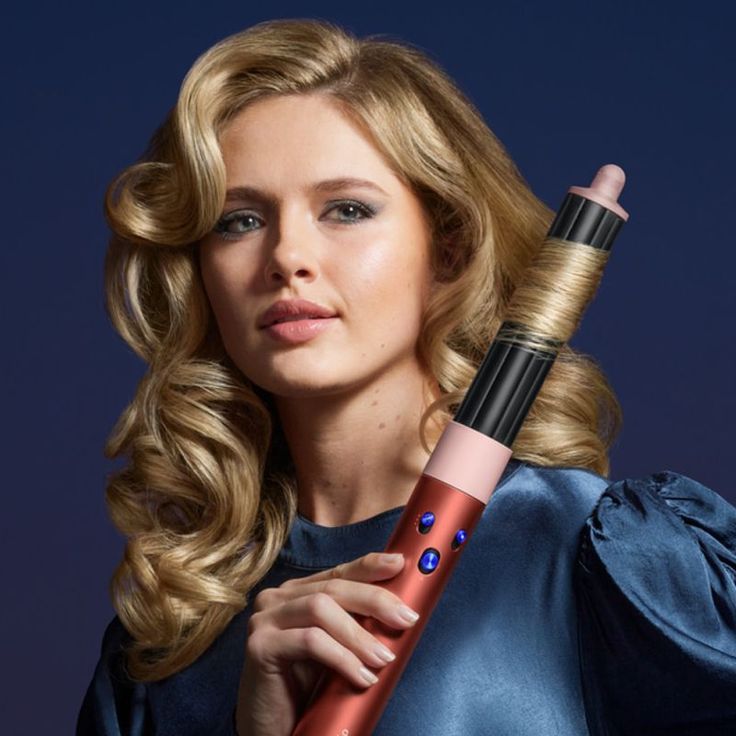 a girl holding dyson airwrap and curling her hair